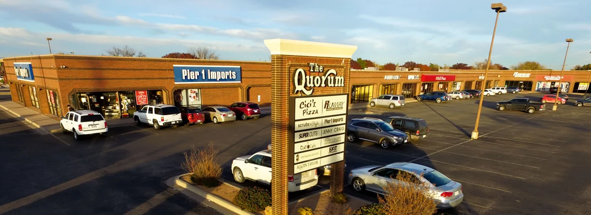 The Quorum monument sign and surrounding storefronts, photographed in 2015